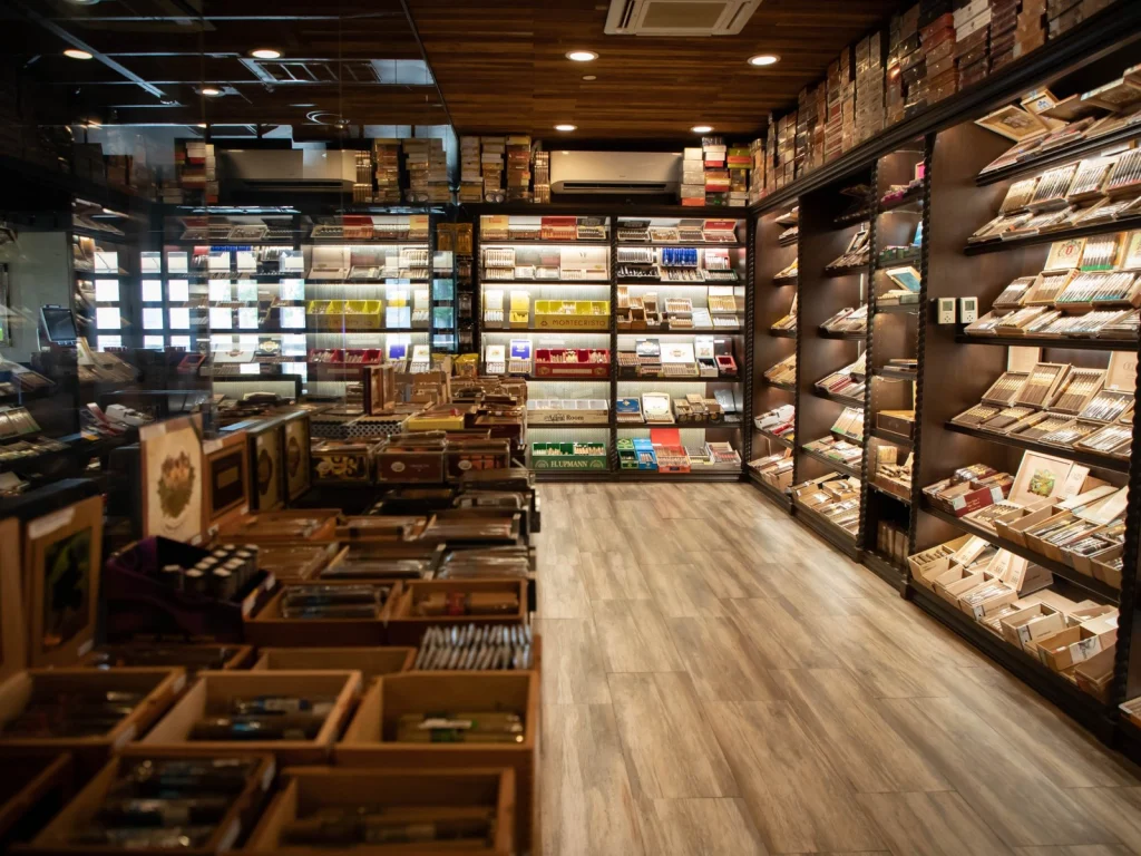 Walk-in humidor at Fox Cigar Bar Scottsdale with lit shelves of cigar boxes and a wood plank floor