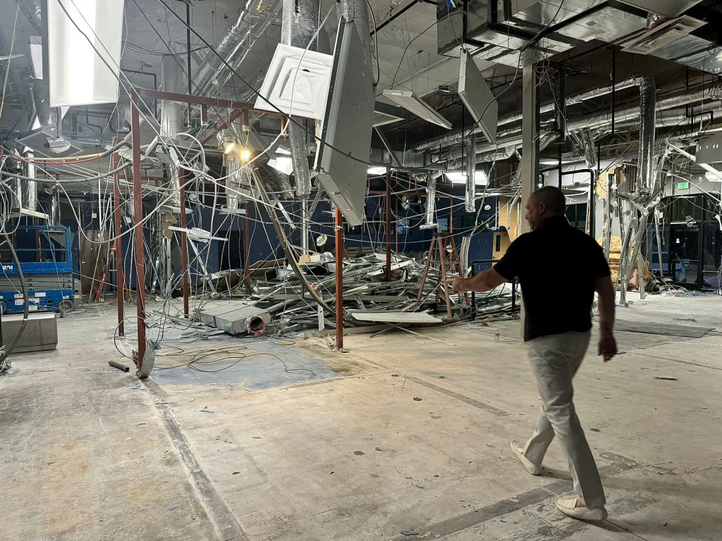 The stripped interior of the Surprise site during demolition, with ceiling framing exposed
