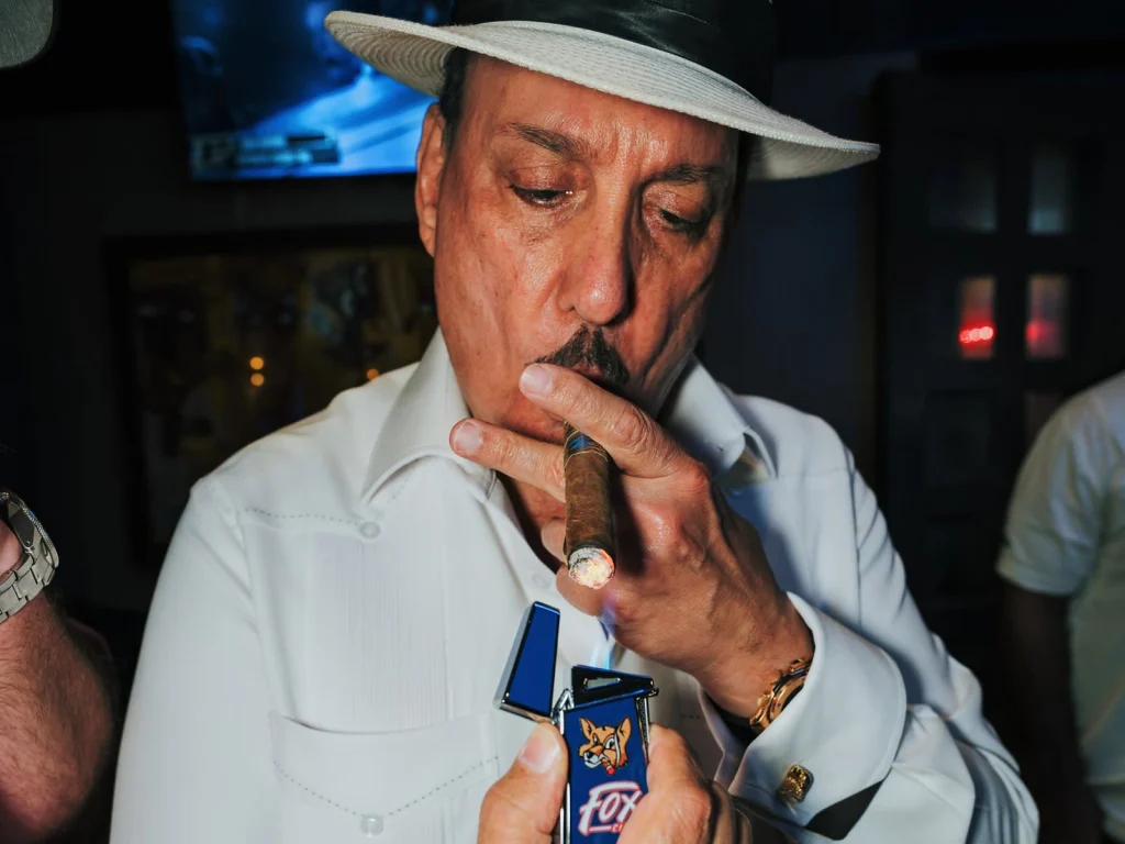 Carlito Fuente lights a premium cigar with a Fox Cigar torch lighter during Fuente Friday.