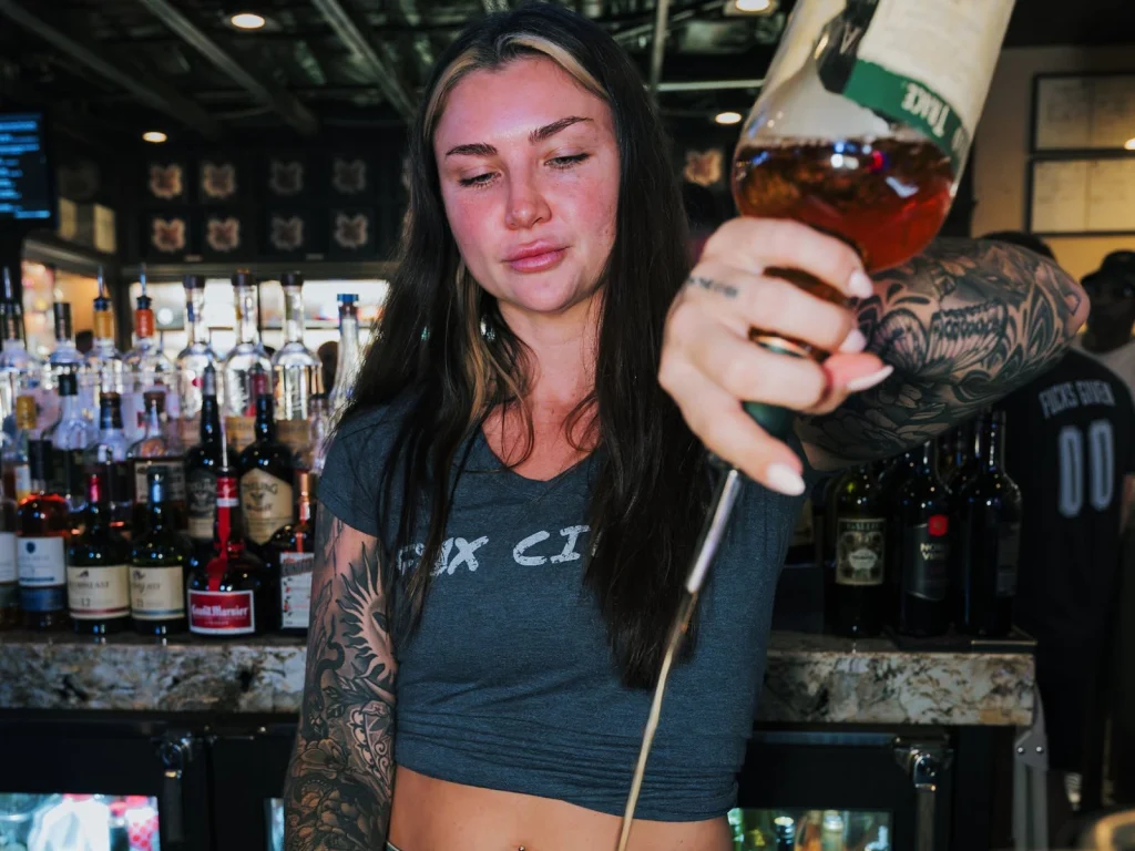 A Fox Cigar Bar bartender stirs a whiskey cocktail to pair with Fuente cigars.