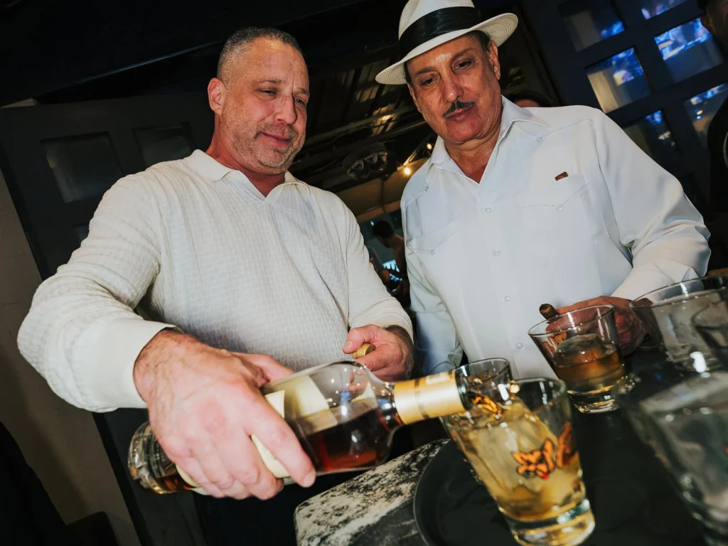 A celebratory whiskey pour at the bar as Carlito Fuente looks on during Fuente Friday.