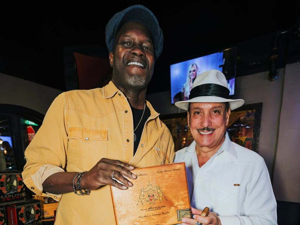 A guest holds an Arturo Fuente Reserva Superior Limitada box with Carlito Fuente.