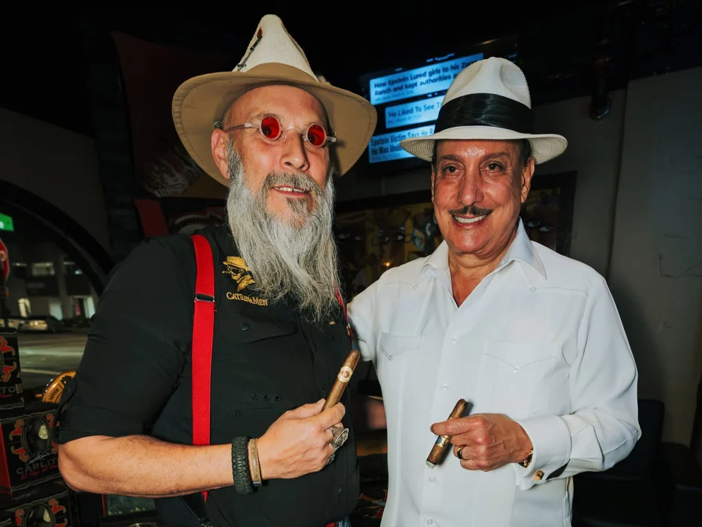 A guest shares a smoke and a laugh with Carlito Fuente by the Fox Cigar Bar patio doors.